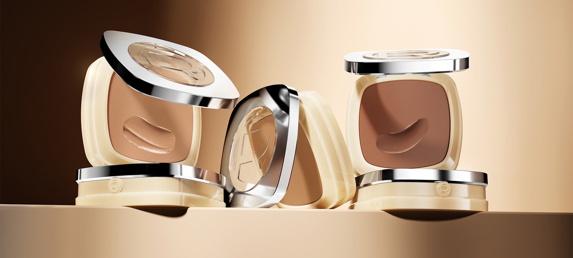 Quatre poudriers carrés de fond de teint L'Oréal dans diverses teintes allant du beige clair au bronzé foncé, présentés sur un fond marron doré chaud.