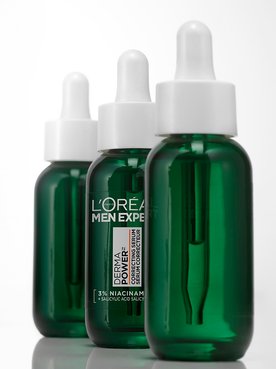 Three green bottles of L'Oréal Men Expert Power Age Correcting Serum with droppers, lined up on a white background.