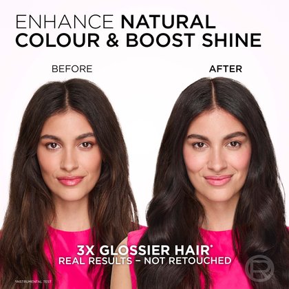 A split image showing a woman's hair and facial expression before and after a treatment designed to enhance natural color and boost shine. On the left, labeled "BEFORE," she has long, wavy, dark brown hair that appears somewhat dry and less vibrant, with a neutral expression. On the right, labeled "AFTER," her hair is a richer, deeper dark brown with a noticeable glossy sheen and more defined waves. She is smiling gently, and her complexion is fresh with a subtle pink flush. The text at the top reads: "ENHANCE NATURAL COLOUR & BOOST SHINE." Below the images, it states: "3X GLOSSIER HAIR*" and "REAL RESULTS - NOT RETOUCHED," with an asterisk indicating "*INSTRUMENTAL TEST."