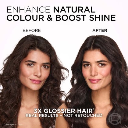 A split image showing a woman with long, wavy dark hair before and after a treatment designed to enhance natural color and boost shine. On the left, labeled "BEFORE," her hair is a dark brown, appearing somewhat matte, and her expression is neutral. On the right, labeled "AFTER," her hair is a richer, darker brown with a noticeable glossy finish, and her waves appear more vibrant and defined. She is smiling gently. The text at the top reads: "ENHANCE NATURAL COLOUR & BOOST SHINE." Below the images, it states: "3X GLOSSIER HAIR*" and "REAL RESULTS - NOT RETOUCHED," with an asterisk indicating "*INSTRUMENTAL TEST."