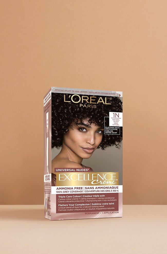 Boîte de coloration capillaire L'Oréal Excellence Crème Universal Nudes 1N noir très foncé, affichant une femme souriante aux cheveux noirs très bouclés et volumineux.