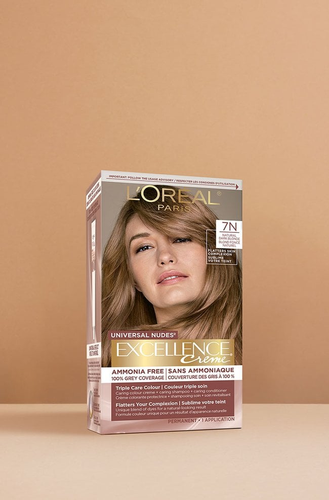 L'Oréal Excellence Crème Universal Nudes 7N Golden Blonde hair dye box, featuring a smiling woman with smooth, medium-length golden blonde hair.