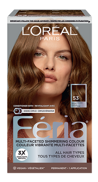 Boîte de teinture capillaire L'Oréal Paris Féria 'Multi-Faceted Shimmering Colour' (Couleur Vibrante Multi-Facettes) en teinte 53 Medium Golden Brown / Moyen Blond Doré. La boîte présente une femme aux cheveux ondulés et brillants, d'un brun doré moyen, et un swatch carré de la couleur finale avec le numéro '53' et la mention 'MEDIUM GOLDEN BROWN / MOYEN BLOND DORÉ'. Le texte promotionnel inclut 'CONDITIONER WITH + REVITALISANT AVEC BONDING COMPLEX + COMPLEXE RÉPARATEUR', '3X HIGHLIGHTS REFLETS', 'ALL HAIR TYPES TOUS TYPES DE CHEVEUX', 'VEGAN • VÉGÉTALIEN', et 'PERMANENT • 1 APPLICATION'. En haut, un bandeau rappelle de 'IMPORTANT: FOLLOW THE USAGE ADVISORY / RESPECTER LES CONSIGNES D'UTILISATION