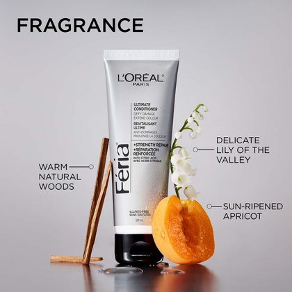 L'Oréal Paris Féria Ultimate Conditioner silver tube centred on a neutral background, surrounded by three fragrance-evoking ingredients with label callouts. To the left: wooden sticks labelled "Warm Natural Woods." To the upper right: white lily of the valley flowers labelled "Delicate Lily of the Valley." To the lower right: a halved sun-ripened apricot labelled "Sun-Ripened Apricot." Headline at the top reads: "Fragrance."