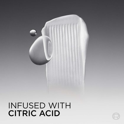Close-up studio shot on a dark gradient background showing a thick white conditioner texture smear with two glossy silver liquid droplets beside it, representing the active citric acid ingredient. Text at the bottom reads: "Infused with Citric Acid."