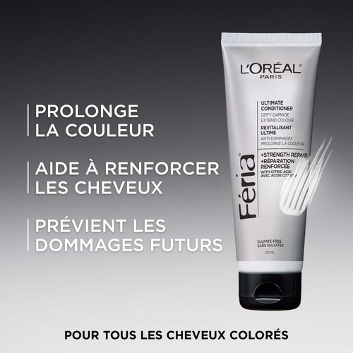 Tube du Revitalisant Ultime Féria de L'Oréal Paris, en emballage argenté avec un bouchon noir, sur fond dégradé sombre. Le texte superposé met en avant trois bénéfices clés : « Prolonge la couleur des cheveux », « Aide à renforcer les cheveux » et « Protège des dommages futurs ». Formule +Réparation Renforcée avec acide citrique. Sans sulfates, 120 mL. Mention en bas : « Pour tous les cheveux colorés. »