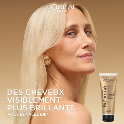 Une femme aux longs cheveux blonds lisses regarde par-dessus son épaule avec un léger sourire. Le fond est un dégradé doré doux. Le grand texte blanc à gauche dit : « Cheveux visiblement plus brillants. Parce que vous le valez bien. » Une image du tube de revitalisant se trouve dans le coin inférieur droit.