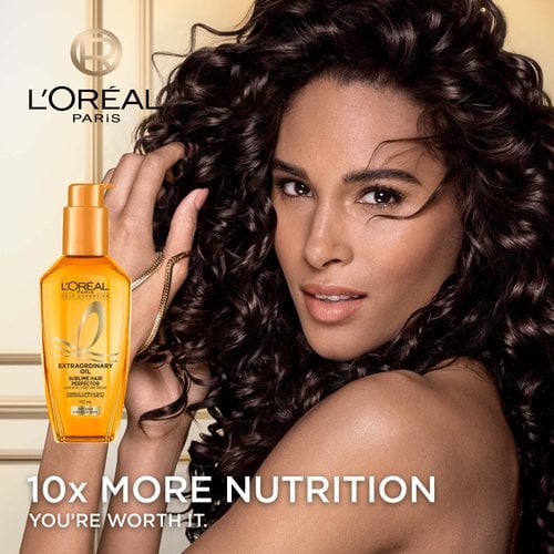 A woman with curly hair moisturized with L'Oréal Paris sublime perfector oil.