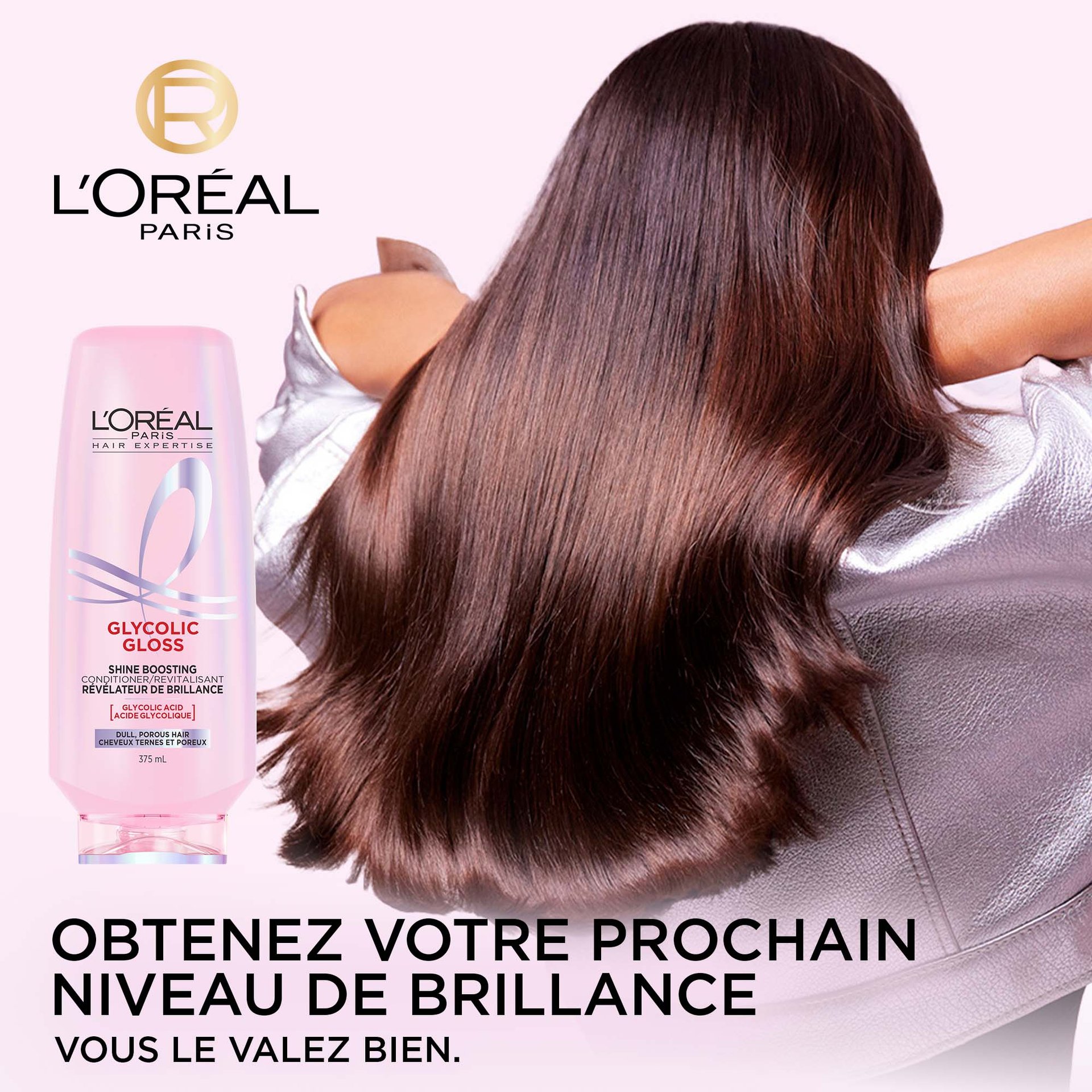Une bouteille (375 mL) de l'après-shampooing révélateur de brillance L'Oréal Paris Glycolic Gloss est placée à côté d'un modèle vu de dos, mettant en valeur ses longs cheveux foncés, incroyablement brillants et lisses. Le texte "GET NEXT-LEVEL SHINE YOU'RE WORTH IT." est visible en bas de l'image.