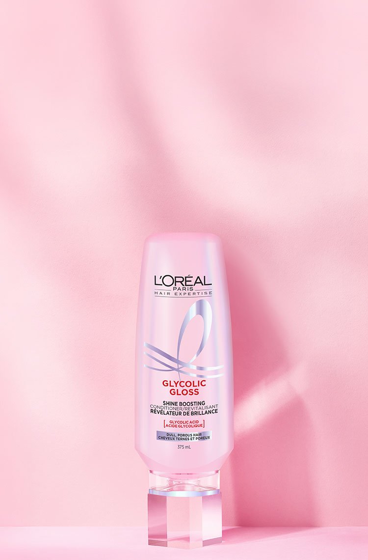 A L'Oréal Glycolic Gloss conditioner pump bottle, on a pink background with radial luminous lines.