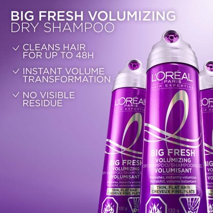 Two purple cans of L'Oréal Paris Hair Expertise Big Fresh Volumizing Dry Shampoo. White checkmarks highlight three product benefits: 'Cleans hair for up to 48H,' 'Instant volume transformation,' and 'No visible residue.'