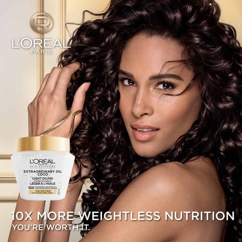 A woman with voluminous, shiny dark curly hair looking at the camera. In the bottom left, the L'Oréal Paris Coco Light Oil Mask jar is displayed with the text "10x More Weightless Nutrition".
