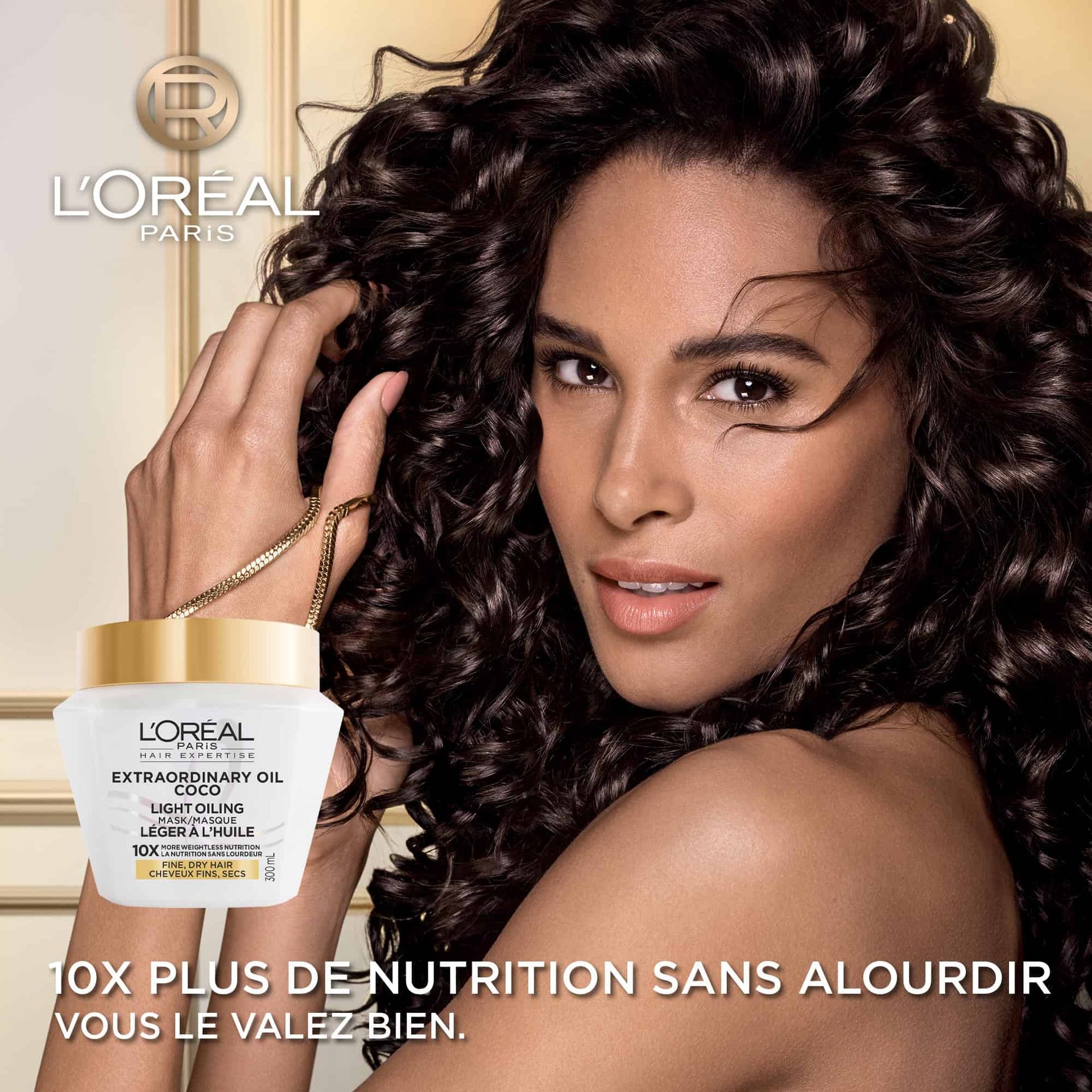 Une femme aux cheveux bouclés foncés, volumineux et brillants regardant l'objectif. En bas à gauche, le pot de masque à l'huile de coco s'affiche avec le texte « Nutrition 10x plus légère ».