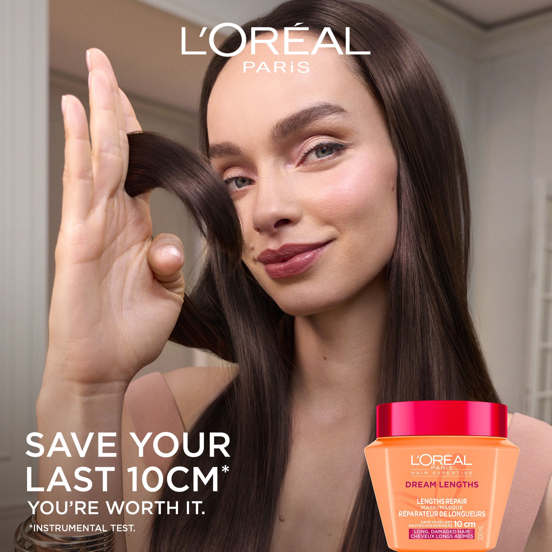 A woman with long, shiny dark hair sliding her fingers through her strands. To her left, the text says "Save your last 10 cm", with the orange hair mask jar in the bottom corner.