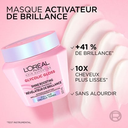 Gros plan du pot de masque L'Oréal Paris Glycolic Gloss sur un fond de crème rose ondulé et lisse. Le texte indique : « Masque d'activation de la brillance : +41 % de brillance, cheveux 10x plus lisses, n'alourdit pas ».