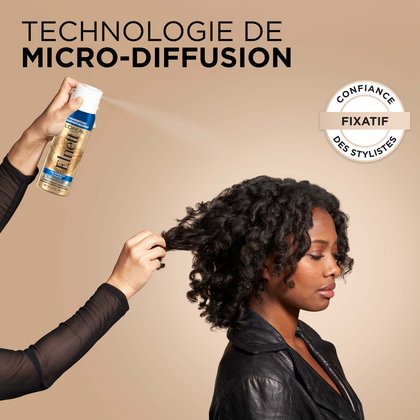 Une femme finalise son brush et sa coiffure avec le spray fixateur elnett