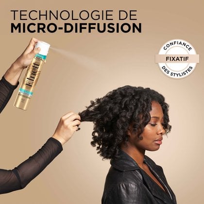 Une femme finalise son brush et sa coiffure avec le spray fixateur elnett