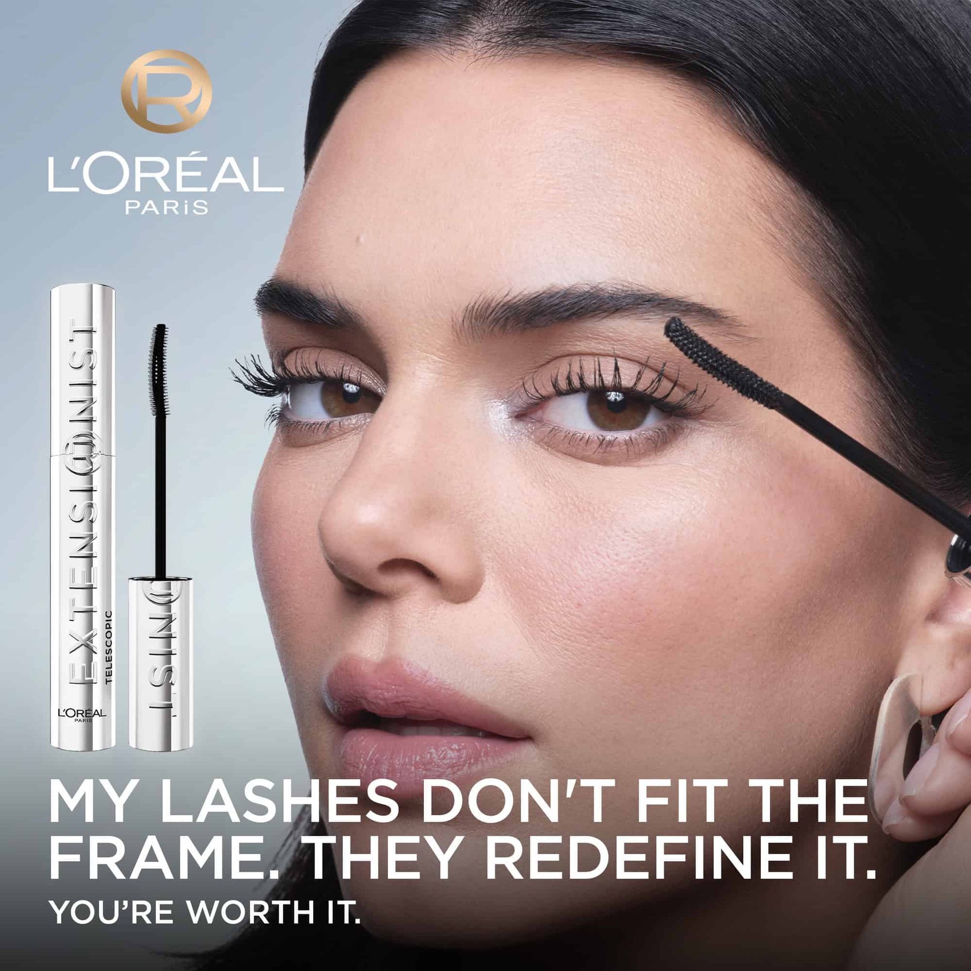 Kendall Jenner, with beautifully enhanced lashes, holds the L'Oréal Telescopic Extensionist mascara wand near her eye. The L'Oréal Paris logo is in the top left. Text states: "MY LASHES DON'T FIT THE FRAME. THEY REDEFINE IT. YOU'RE WORTH IT."