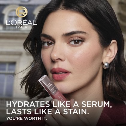 Kendall Jenner, L'Oréal Paris ambassador, holds the L'Oréal Paris Hyaluron Tint product to her lips. Promotional text reads: 'HYDRATES LIKE A SERUM, LASTS LIKE A STAIN. YOU'RE WORTH IT.