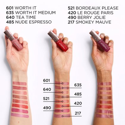 Échantillons des teintes L'Oréal Paris Hyaluron Tint appliqués sur des bras de différentes couleurs de peau, montrant une variété de nuances allant des nudes aux rosés et aux mauves. Les noms et numéros des teintes sont listés, incluant '601 WORTH IT', '635 WORTH IT MEDIUM', '640 TEA TIME', '485 NUDE ESPRESSO', '521 BORDEAUX PLEASE', '420 LE ROUGE PARIS', '490 BERRY JOLIE', '217 SMOKEY MAUVE'