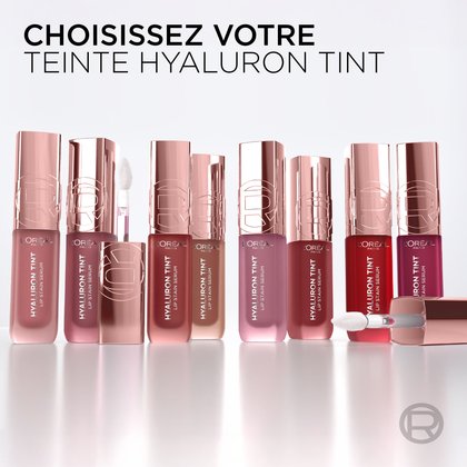 Une rangée de neuf flacons du produit L'Oréal Paris Hyaluron Tint, chacun représentant une teinte différente, alignés sur une surface réfléchissante blanche, invitant l'utilisateur à choisir sa couleur. Le texte demande : 'CHOISISSEZ VOTRE TEINTE HYALURON TINT