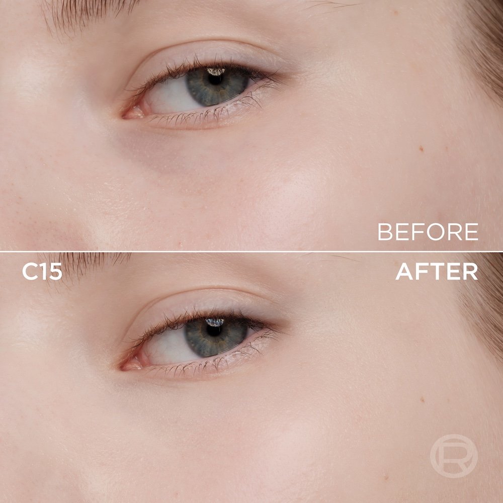 A split image showing a before and after comparison of a light to medium-skinned person's under-eye and cheek area. The top section, labeled 'BEFORE', displays skin with a few slight imperfections, subtle under-eye discoloration, and subtle eye makeup. The bottom section, labeled 'W253' and 'AFTER', shows the same facial area with noticeably more even-toned, smoother skin, and reduced imperfections, following the application of a cosmetic product. The eye makeup remains subtle. A subtle 'R' logo is also visible in the bottom right of the 'AFTER' portion