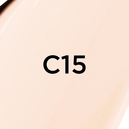 Un gros plan d'un fond de teint ou d'une texture crémeuse de couleur beige très clair, presque blanc cassé, avec le texte noir en gras 'C15' centré sur l'image, indiquant probablement une teinte de produit