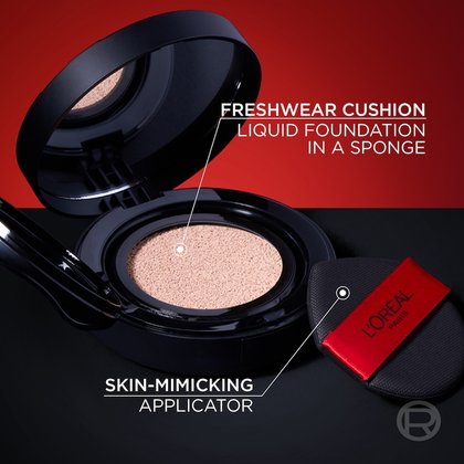 Close-up of an open L'Oréal Paris Freshwear Cushion compact. It shows the liquid foundation-infused sponge and a skin-mimicking applicator resting next to it. Lines point to the cushion and applicator with descriptions 'FRESHWEAR CUSHION LIQUID FOUNDATION IN A SPONGE' and 'SKIN-MIMICKING APPLICATOR