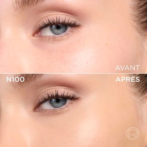 Un gros plan d'un fond de teint ou d'une texture crémeuse de couleur beige clair avec des sous-tons neutres ou légèrement rosés, avec le texte noir en gras 'N100' centré sur l'image, indiquant probablement une teinte de produit