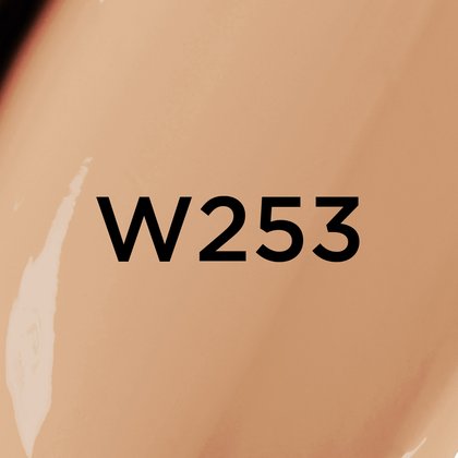 Un gros plan d'un fond de teint ou d'une texture crémeuse de couleur beige moyen à chaud avec le texte noir en gras 'W253' centré sur l'image, indiquant probablement une teinte de produit.