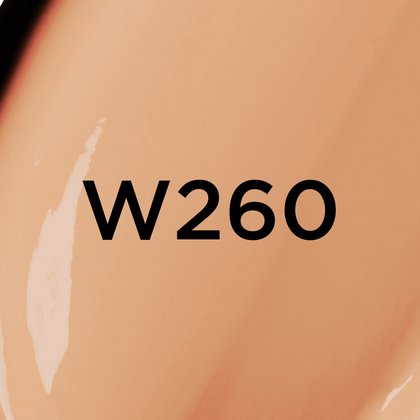 Un gros plan d'un fond de teint ou d'une texture crémeuse de couleur beige moyen à foncé avec des sous-tons chauds, avec le texte noir en gras 'W260' centré sur l'image, indiquant probablement une teinte de produit.
