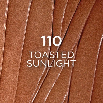 A close-up, textured swatch of makeup in shade '110 Toasted Sunlight', displaying a rich, warm bronze color with visible brush strokes, indicating a creamy or liquid product.