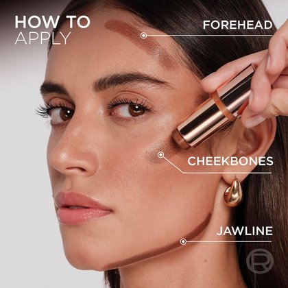 close-up of a woman's face with light-medium skin, demonstrating how to apply the Lumi Bronze stick. Lines on her forehead, cheekbones, and jawline indicate the application areas, with text labels 'FOREHEAD', 'CHEEKBONES', and 'JAWLINE' beside each area. A hand holds the Lumi Bronze stick, applying it to her cheekbone.