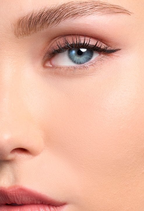 Close-up "After" shot of a model's face with a fair skin tone and blue eyes, showcasing a smooth, natural, and flawless foundation coverage.