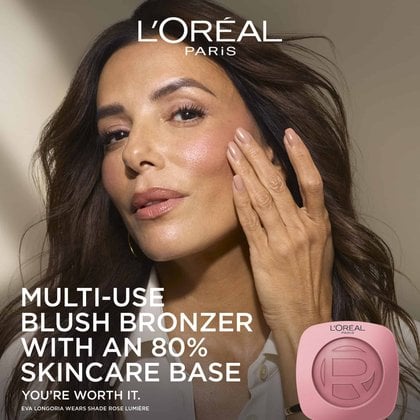 Close-up of a smiling woman with glowing, hydrated skin next to a L'Oréal Paris blush bronzer compact, featuring the text "MULTI-USE BLUSH BRONZER WITH AN 80% SKINCARE BASE".