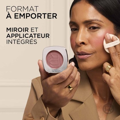 Une femme tenant le boîtier ouvert pour montrer le miroir intégré et appliquant le produit à l'aide de la houppette applicatrice, avec la mention "ON THE GO FORMAT INTEGRATED MIRROR AND APPLICATOR".