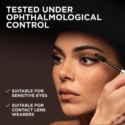A close-up of a woman's face, focusing on her eye as she applies L'Oréal Panorama Mascara. Her lashes appear volumized and lengthened. Text on the image confirms the product's safety: "TESTED UNDER OPHTHALMOLOGICAL CONTROL," "SUITABLE FOR SENSITIVE EYES," and "SUITABLE FOR CONTACT LENS WEARERS."