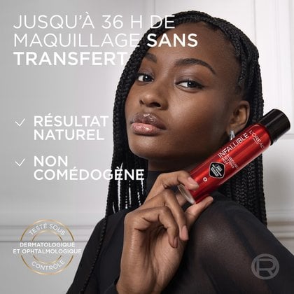 Un portrait en gros plan d'une femme souriante aux cheveux tressés foncés, tenant un flacon rouge de "L'Oréal Infallible 3-Second Setting Mist". Des textes blancs superposés mettent en évidence les avantages du produit : "MAQUILLAGE ANTI-TRANSFERT JUSQU'À 36H", "RÉSULTAT NATUREL", "NON COMÉDOGÈNE", et "TESTÉ SOUS CONTRÔLE DERMATOLOGIQUE & OPHTALMOLOGIQUE", avec un sceau doré circulaire.