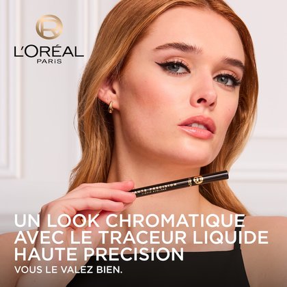 Une mannequin avec un regard souligné d'un eye-liner liquide noir intense, tenant le L'Oréal Paris Haute Précision Liquid Eyeliner noir. Le logo L'Oréal Paris est visible et le texte 'UN LOOK CHROMATIQUE AVEC LE TRACEUR LIQUIDE HAUTE PRÉCISION VOUS LE VALEZ BIEN.' est affiché