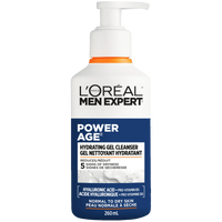 A front-facing studio shot of the L'Oréal Paris Men Expert Power Age Hydrating Gel Cleanser bottle (260ml). The white bottle features a blue and orange label, a pump dispenser, and sits against a background of white soapy foam. Text highlights "Hyaluronic Acid + Pro-Vitamin B5" and "Normal to Dry Skin."