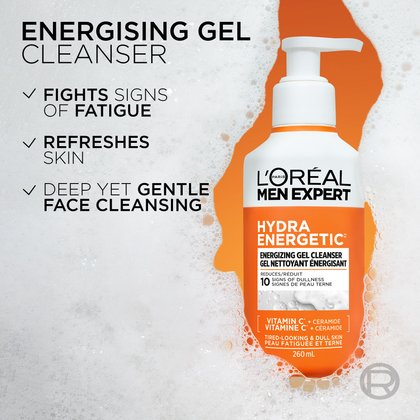 The Hydra Energetic Cleanser bottle is shown partially submerged in thick white foam. Three bullet points on the left read: "FIGHTS SIGNS OF FATIGUE," "REFRESHES SKIN," and "DEEP YET GENTLE FACE CLEANSING."