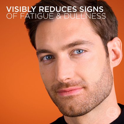 A close-up shot of a man's face with healthy-looking skin against an orange background. Text at the top reads: "VISIBLY REDUCES SIGNS OF FATIGUE & DULLNESS."