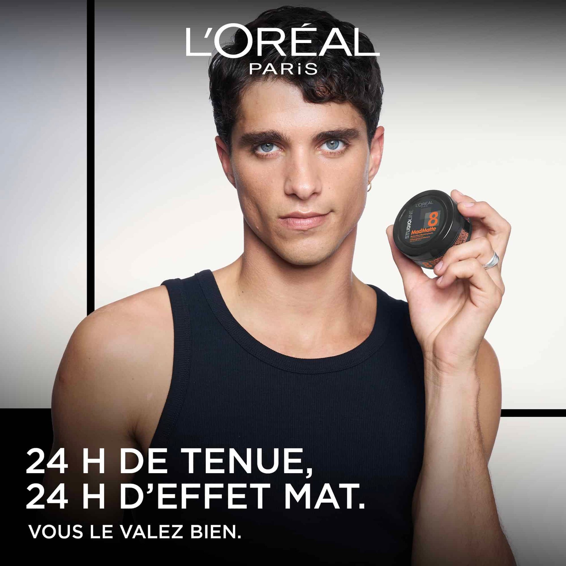 Modèle masculin de L'Oréal Paris tenant un produit coiffant Studio Line, avec le texte « 24 H DE TENUE, 24 H D'EFFET MAT. VOUS LE VALEZ BIEN. »