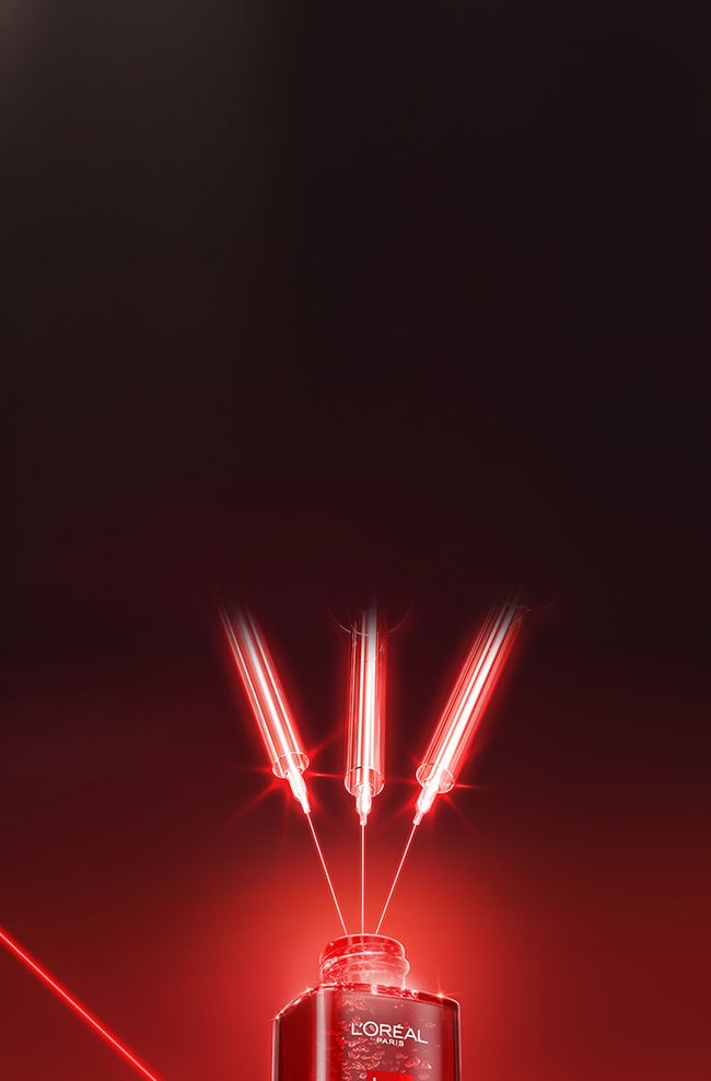 Promotional product photography for L'Oréal Paris Revitalift Laser serum. Set against a dark background with sharp, glowing red laser lines, a dark red glass bottle sits on a reflective surface. Its dropper pipette lies horizontally next to the open bottle. Three glowing red syringes point into the bottle's neck, illustrating a high-tech, medical-grade approach to skincare. The label on the bottle reads 'TRI-PEPTIDES Age-Correcting Serum