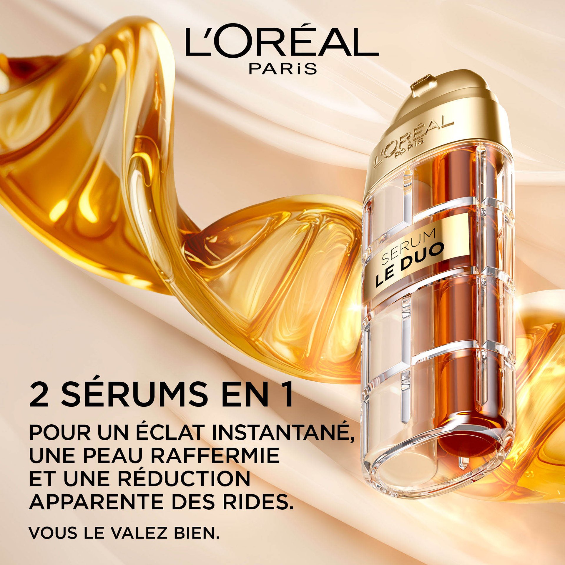 Une bouteille de L'Oréal Paris Age Perfect Sérum Le Duo, présentant deux compartiments de liquide doré, suggérant un sérum à double formule. Le texte indique "2 Sérums en 1", "Éclat instantané, fermeté et réduction visible des rides", et "Parce que vous le valez bien". La bouteille est placée sur un fond de liquide doré fluide, soulignant sa texture riche.