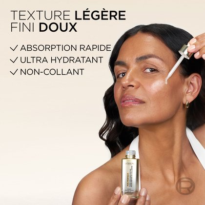 Gros plan d'une femme brune souriante qui applique le sérum sur sa joue avec le compte-gouttes. Le texte indique : « TEXTURE SOYEUSE ET LÉGÈRE. ABSORPTION RAPIDE. ULTRA HYDRATANTE. SANS FINI COLLANT. »